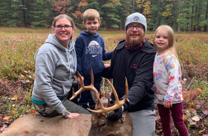 Jennifer Hiller, Levi Hiller, Mike Hiller, and Everly Hiller positioned behind a harvested 10 point whitetail buck. Tall, Wide, bone brown colored, Manistee County whitetail buck tagged.