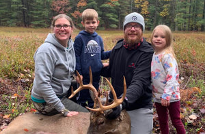 Jennifer Hiller, Levi Hiller, Mike Hiller, and Everly Hiller positioned behind a harvested 10 point whitetail buck. Large Manistee County buck tagged.