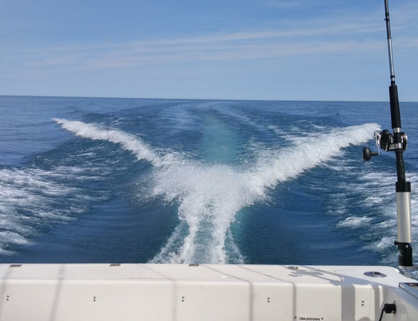 A view from the back of a fishing boat traveling fast with a wake behind it. Lake Michigan fishing.