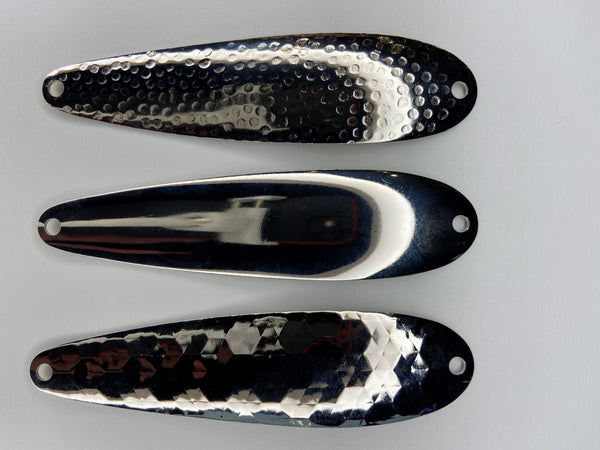 Three fishing spoons orientated horizontally. All three spoons blanks that are nickel-plated.  The top lure has a hammered finish. The middle lure has a smooth finish. The bottom lure has a hex style finish.