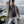 Load image into Gallery viewer, Vic Froman holding a lake trout while standing on the port side of a sportfishing vessel on open water.
